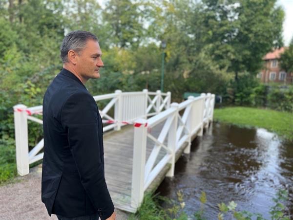 Daniel Holmvin står vid en bro över ett vattendrag i centrala Sala.